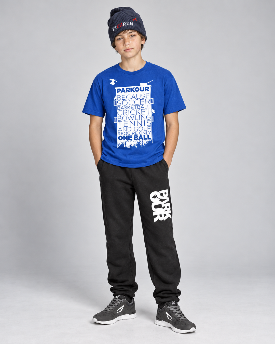 Blå Parkour Takes BALLS T-shirt med sorte/hvide bukser og navy FREERUN-hue – forfra. Sko købes separat.