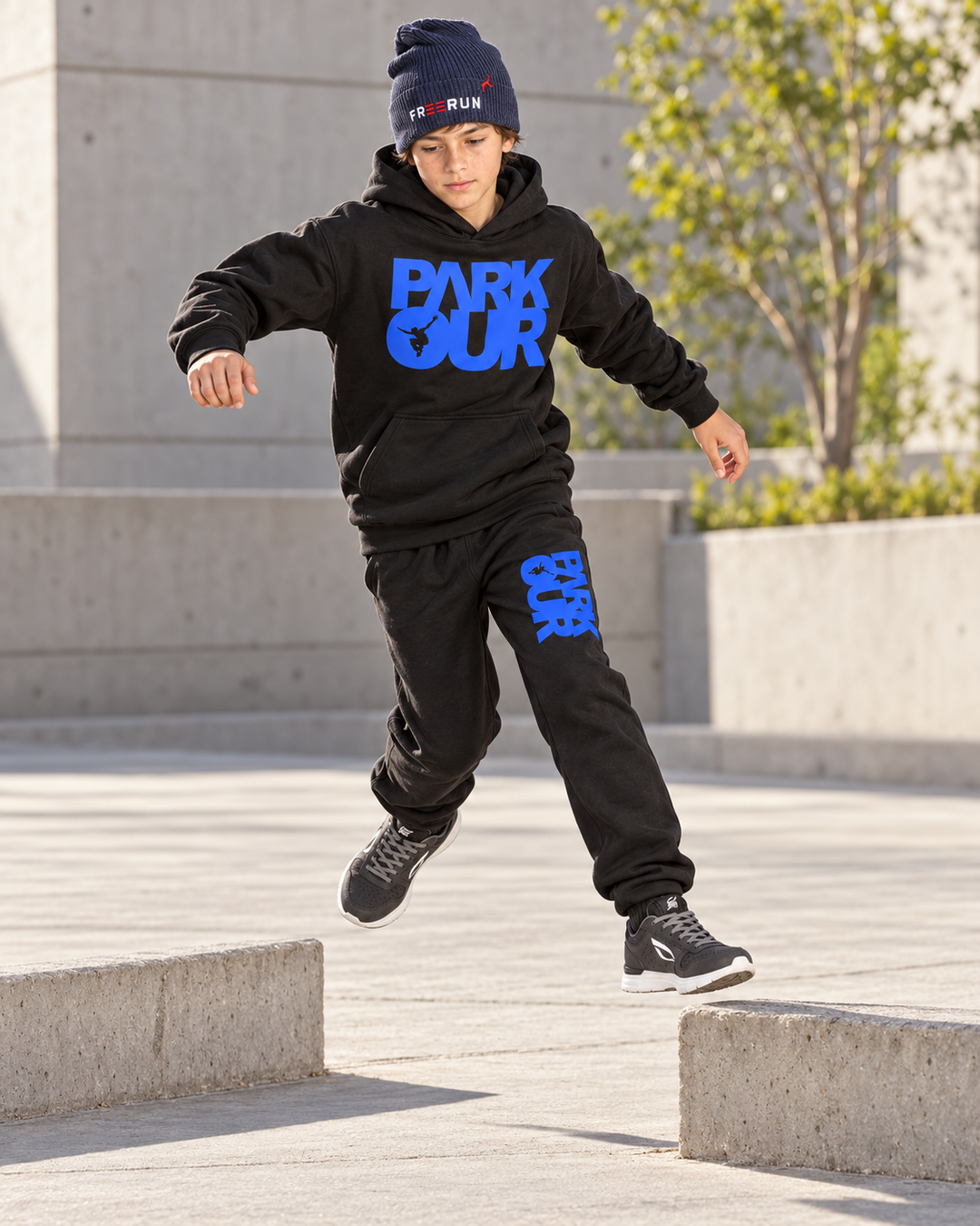 Dreng i sort/blå Parkour-hoodie og bukser under præcisionshop – Sko købes separat.