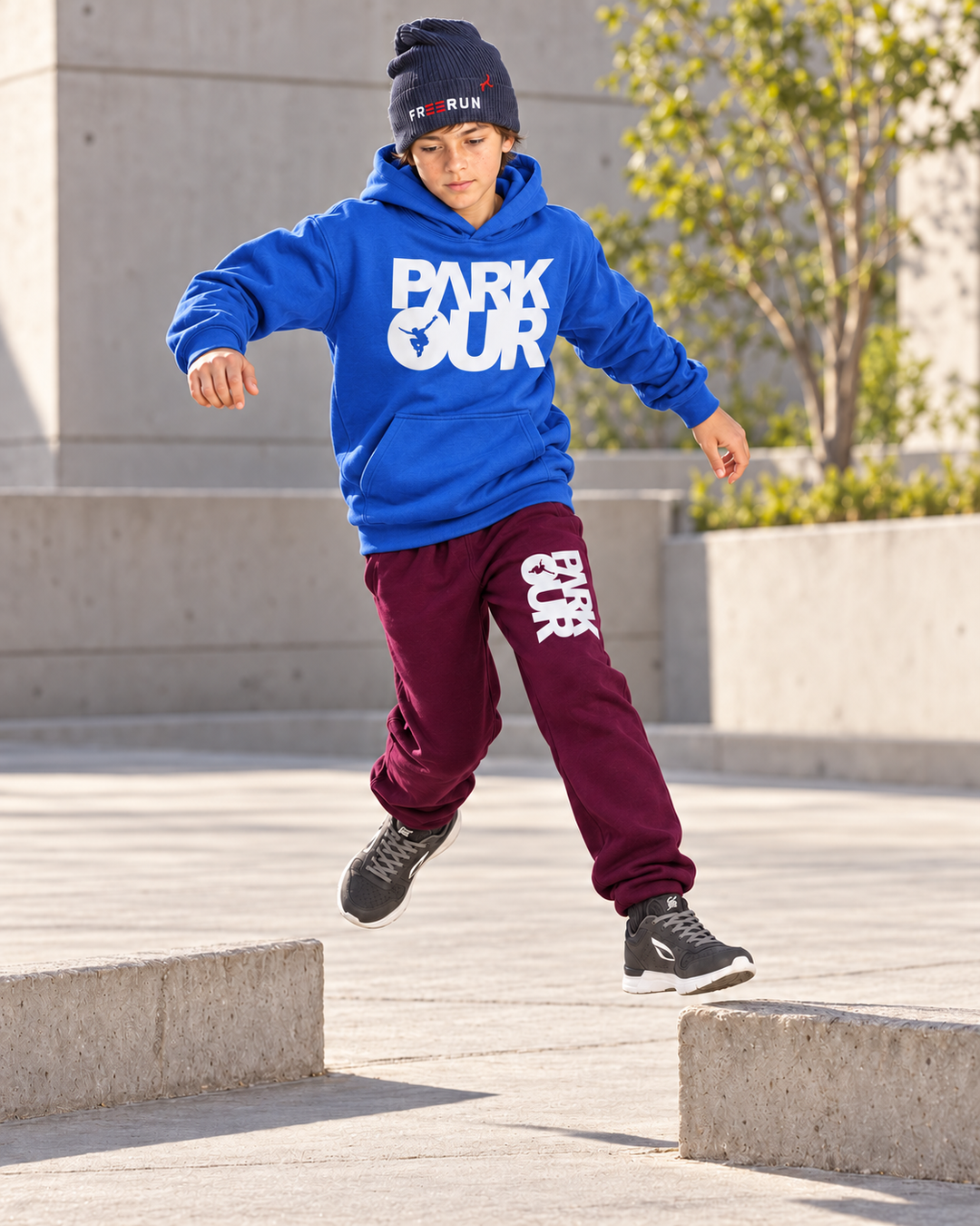 Blå/hvid Parkour-hoodie med bordeaux box-bukser – under parkourtræning.