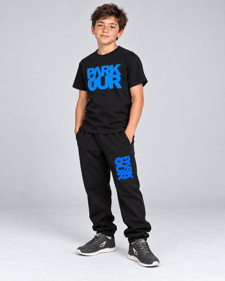 T-shirt og bukser fra den sort/blå startpakke – på model fra siden. Hue og eventuel hoodie ses på pakkens oversigtsfoto. Sko købes separat.