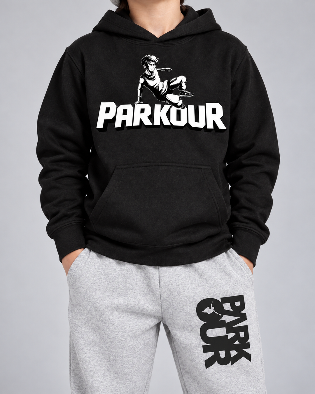 Detalje af Concrete Flows sorte Traceur-hoodie og grå/sorte bukser.