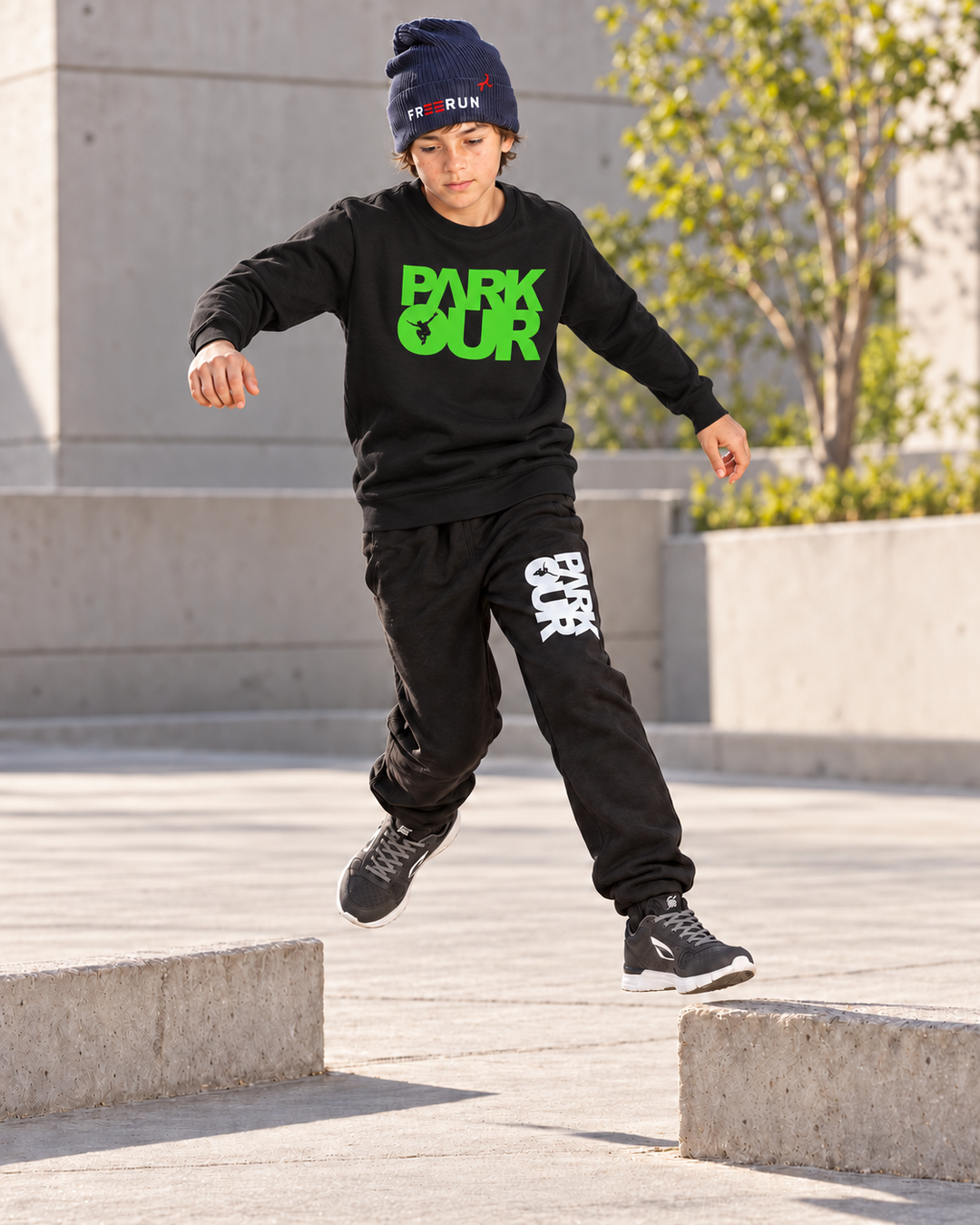 Sort/grøn Parkour-sweatshirt – i brug under parkourtræning.