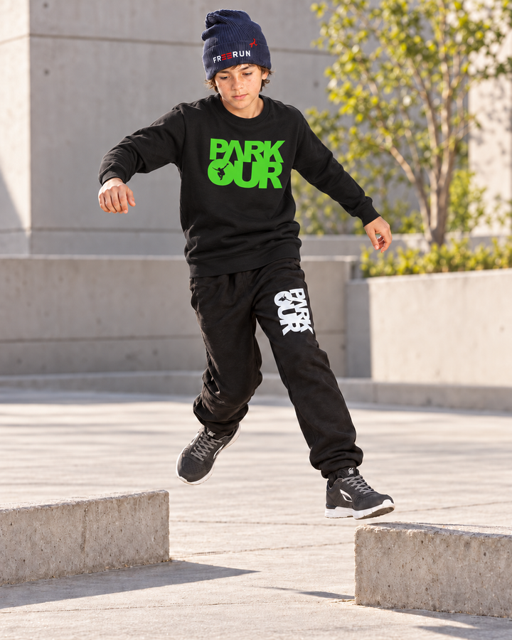 Sort/grøn Parkour-sweatshirt – i brug under parkourtræning.