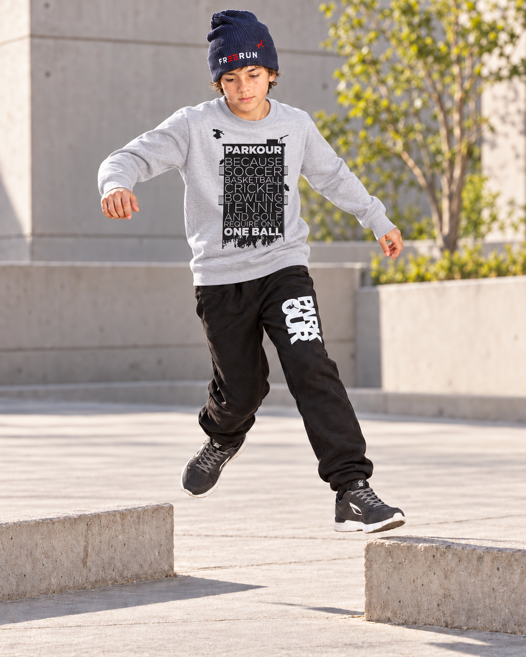 Grå Parkour Takes BALLS-sweatshirt – i brug under parkourtræning.