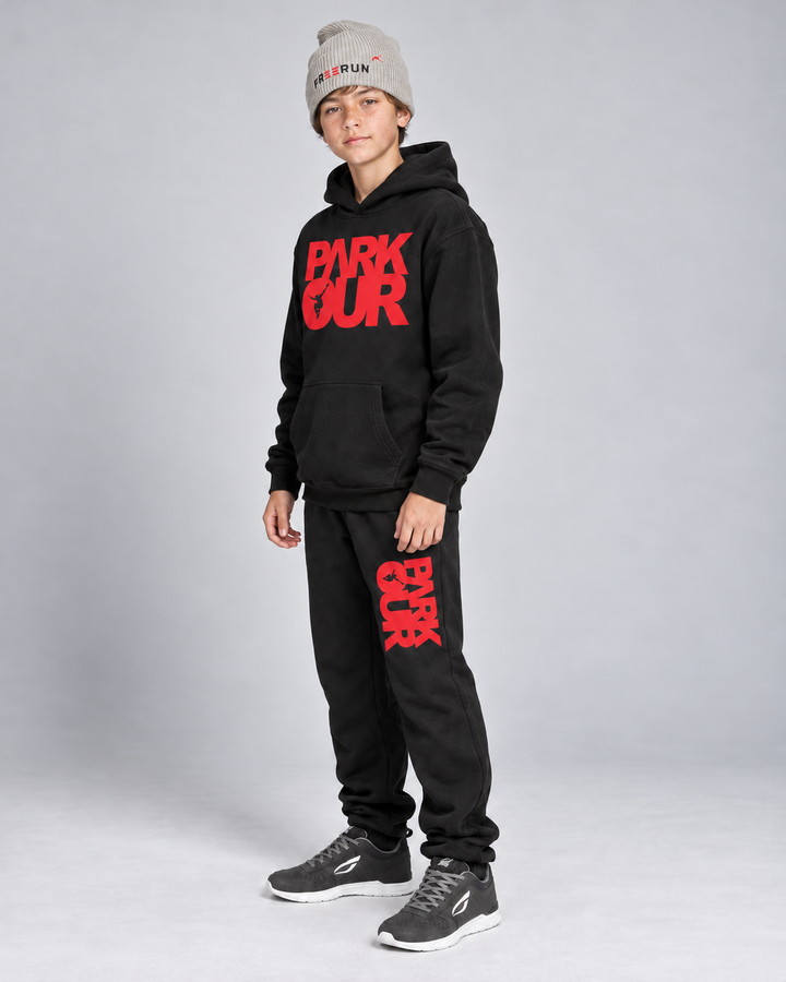 Sort/rød Parkour-hoodie og bukser med grå FREERUN-hue – fra siden. Sko købes separat.