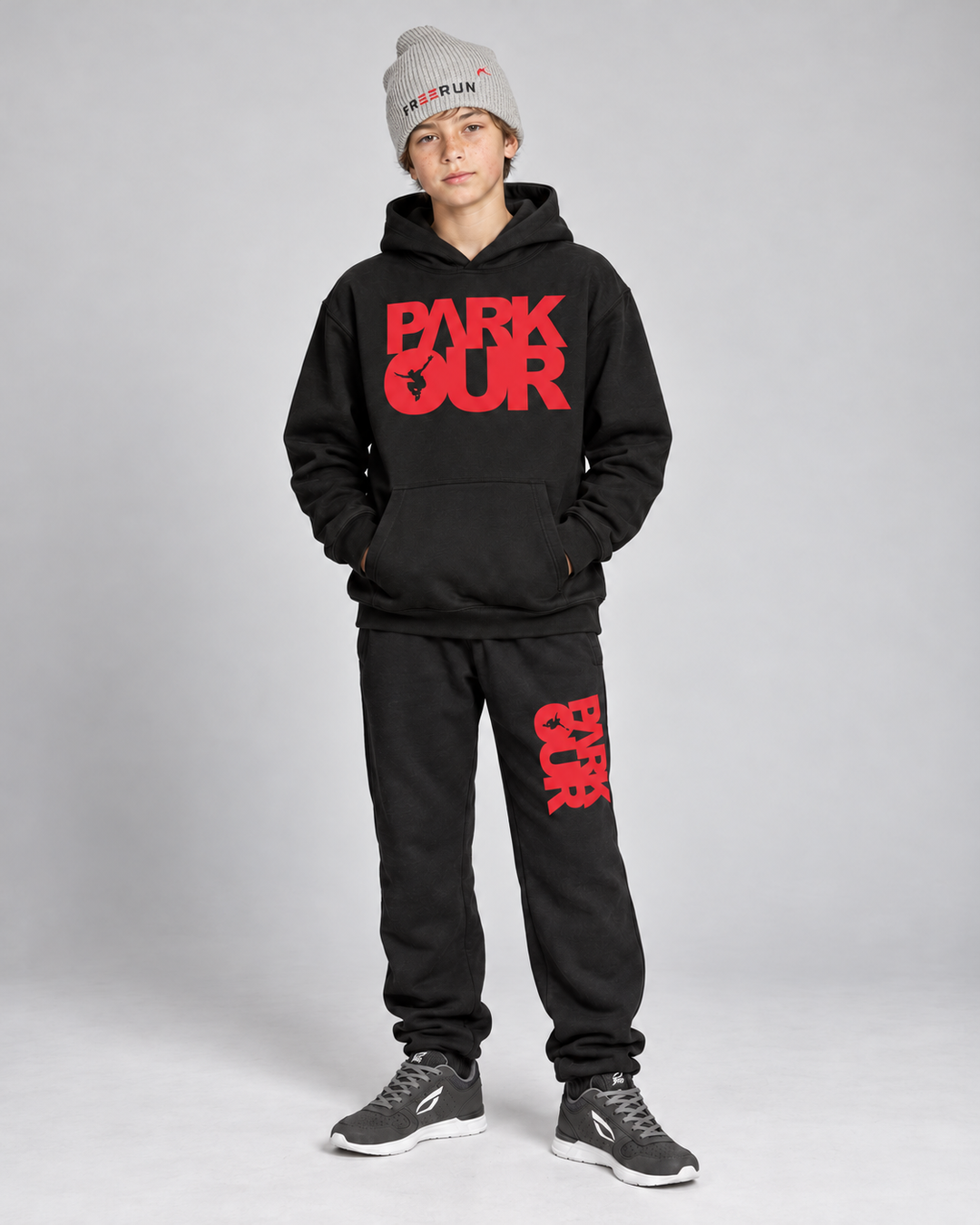 Sort/rød Parkour-hoodie og bukser med grå FREERUN-hue – på model forfra. Sko købes separat.