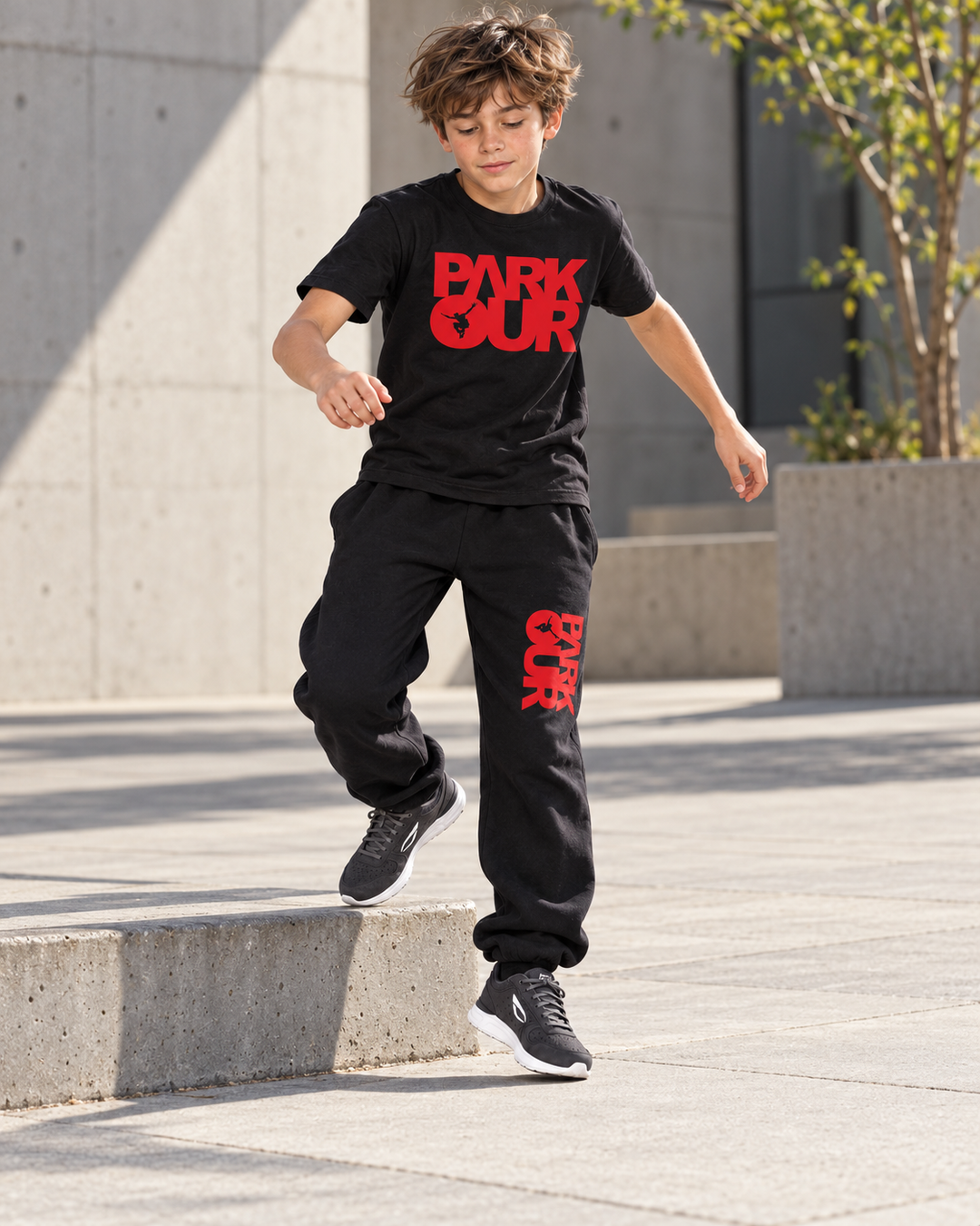 Samme dreng i sort/rødt parkouroutfit og JIYO Flow 2.0 under træning