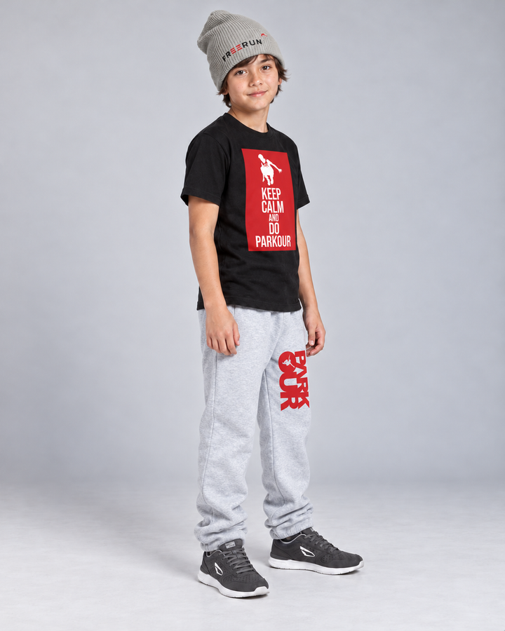 Sort Keep Calm T-shirt og grå/røde bukser med grå FREERUN-hue – fra siden.
