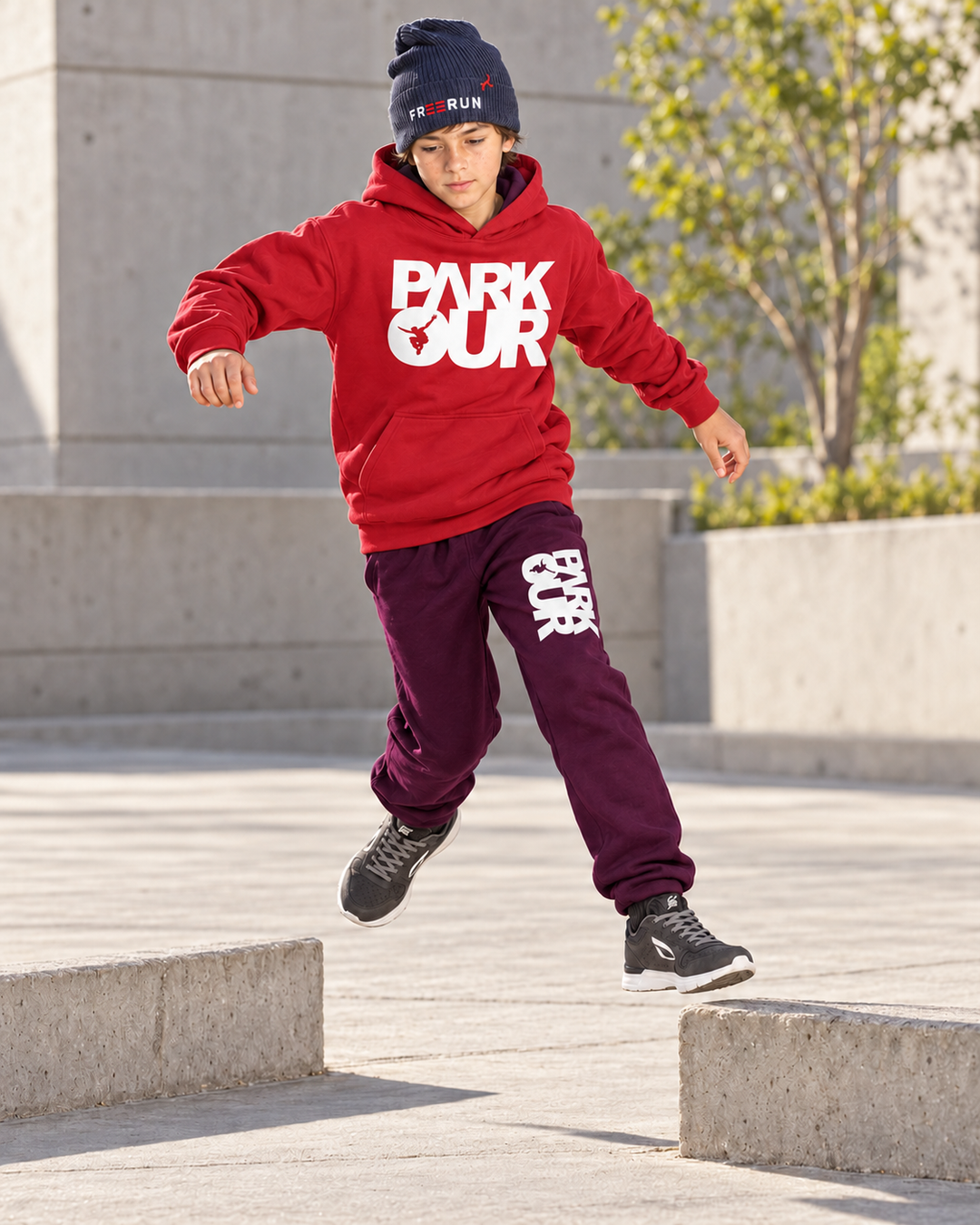 Rød/hvid Parkour-hoodie og bordeaux box-bukser – under parkourtræning.