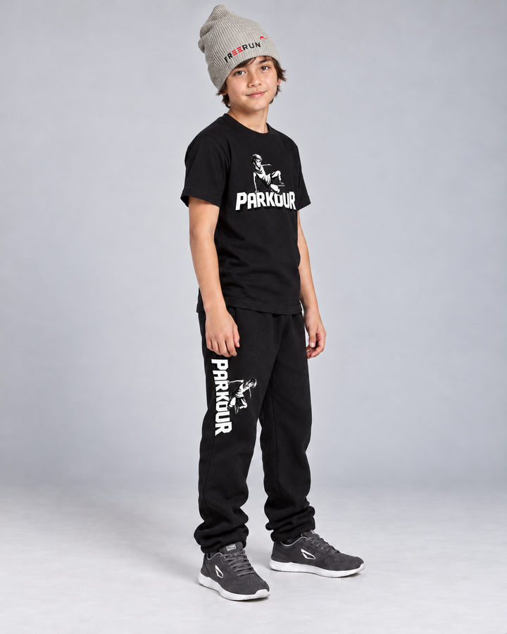 Traceur T-shirt og sorte Traceur-bukser med grå FREERUN-hue – fra siden.