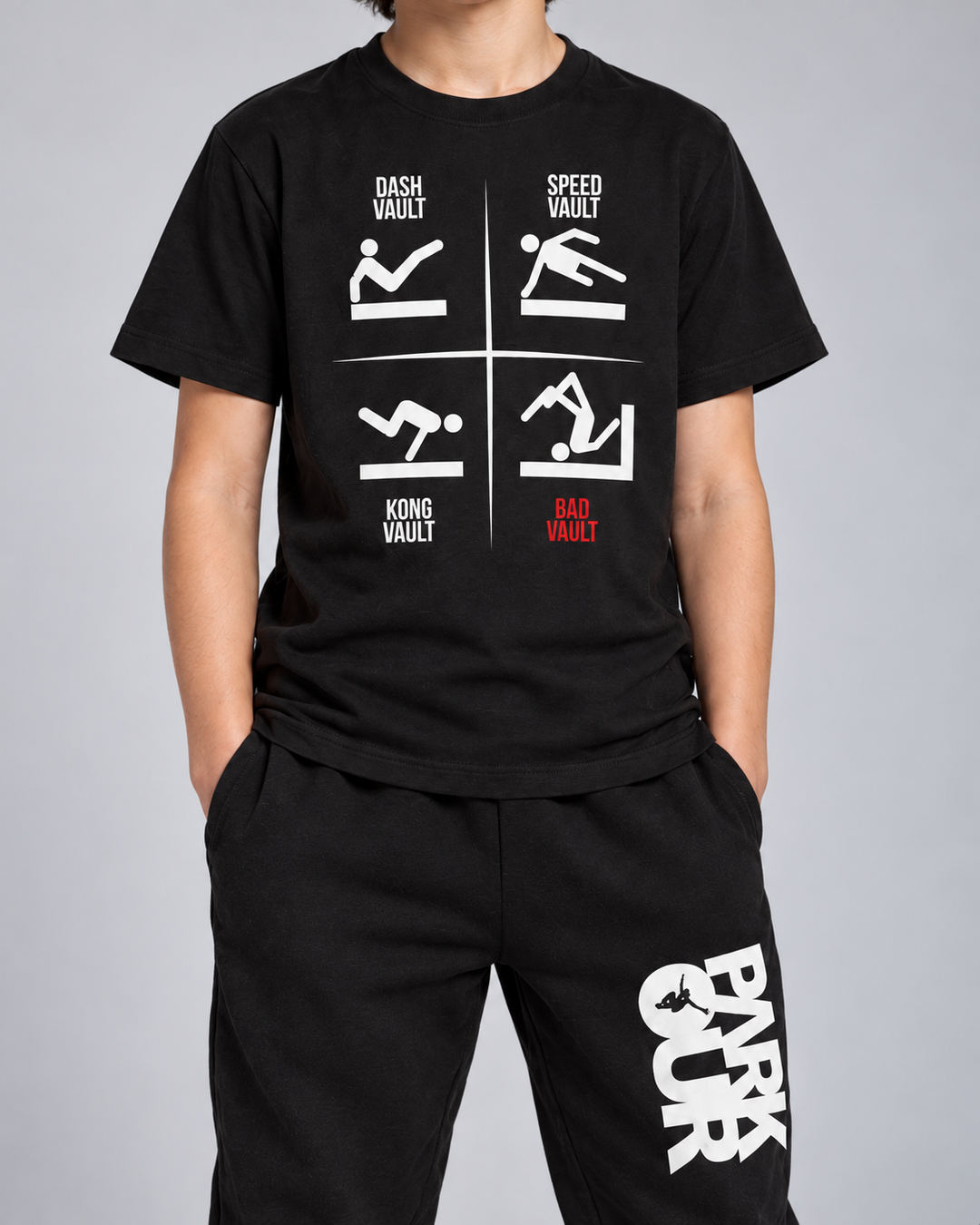 Sort VAULTS T-shirt med sorte/hvide bukser og grå FREERUN-hue – detalje af tryk og materiale. Sko købes separat.
