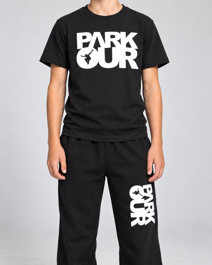 Nærbillede af hvide Parkour box-tryk og sort materiale på T-shirt og YOUNG Street-bukser