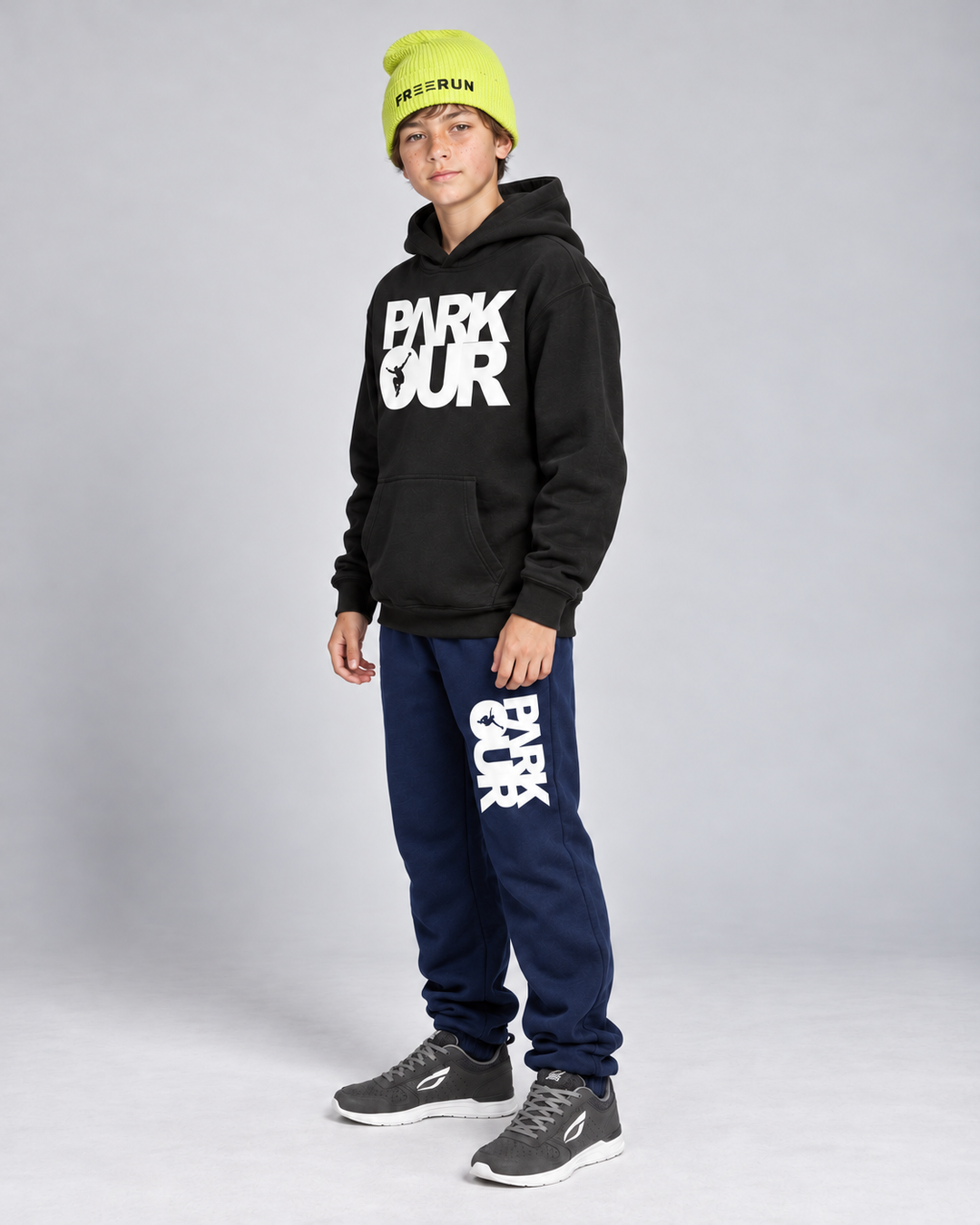 Sort/hvid Parkour-hoodie, navy box-bukser og gul FREERUN-hue – fra siden.
