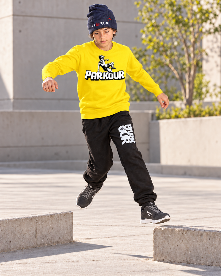 Gul Traceur-sweatshirt – i brug under parkourtræning.